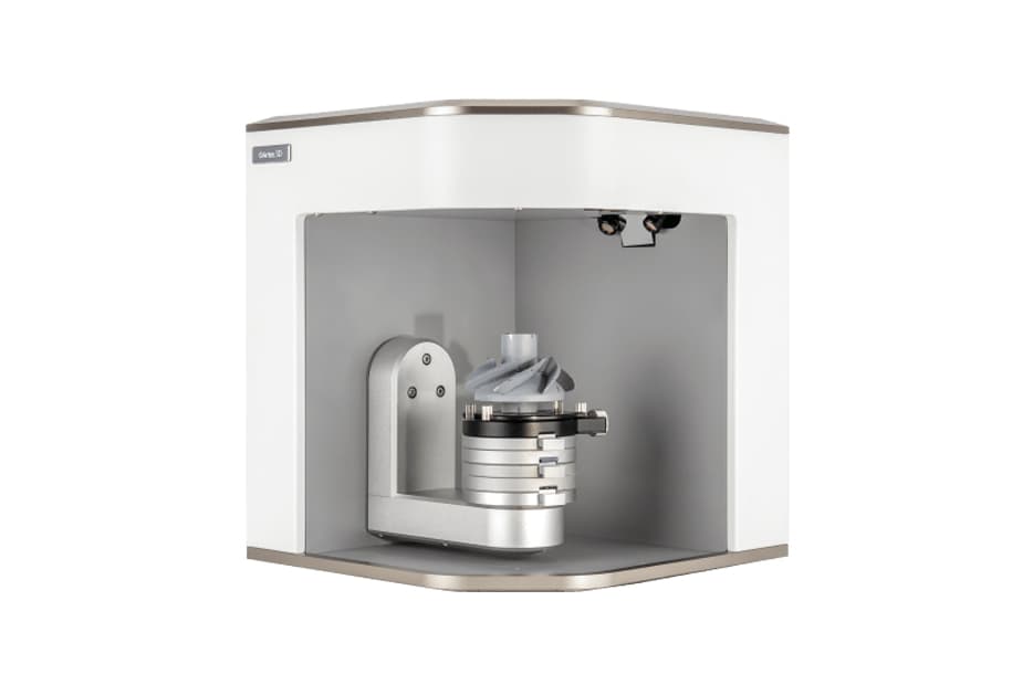 An industrial-grade 3D scanning machine housed within a transparent enclosure, featuring a rotating platform and overhead scanning equipment, likely used for precise, high-resolution object scans.