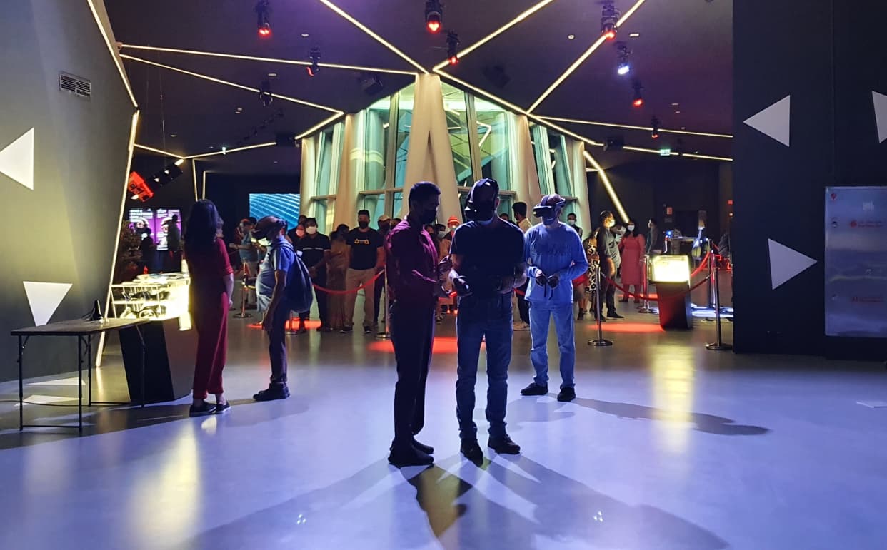 Visitors engage with a VR experience at a brightly lit exhibition space with modern design elements.
