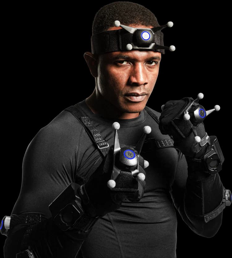 A person equipped with motion capture gear, including a head-mounted camera rig, reflective markers on the face, and sensor-equipped gloves, ready for a performance capture session.