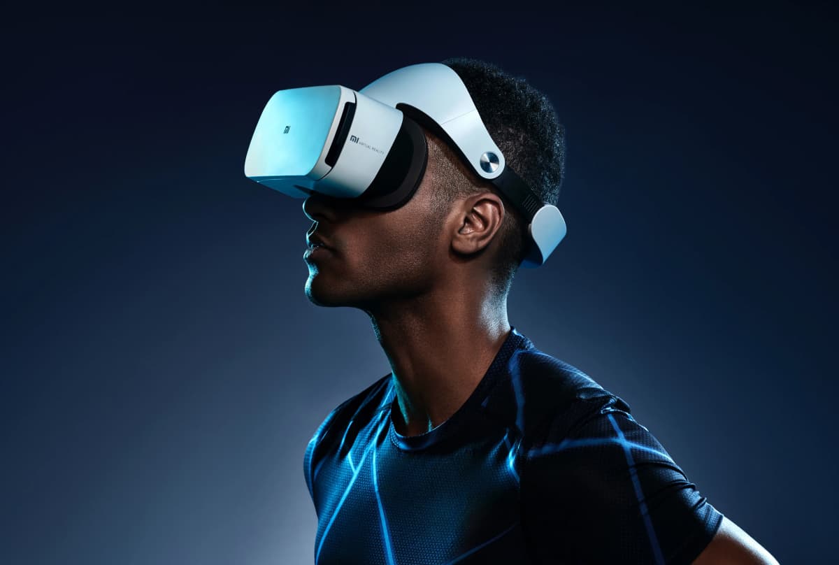 A profile view of a man wearing a virtual reality headset against a dark background, immersed in a VR experience.