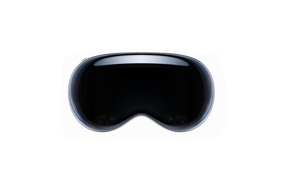 A close-up view of the front of a glossy black Apple Vision Pro VR headset, showing the curved design of the visor which likely shields the user's eyes for a fully immersive visual experience.
